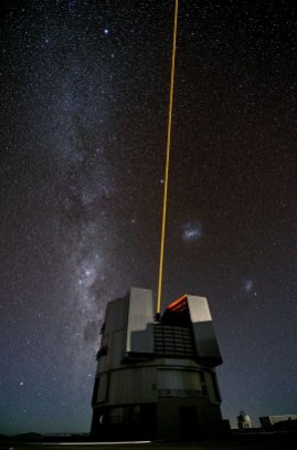 Foto di Gerhard Hüdepohl che ritrae l'ESO’s Very Large Telescope (VLT) durante un test del proprio laser. Sulla sinistra, la Via Lattea. A destra, le due Nubi di Magellano